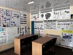 Робочі місця учнів у кабінеті на вул. Миру, 10а, обладнані наочними посібниками про будову автомобіля та дорожню розмітку.