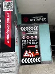 Вхідні двері автошколи «Антарес» у м. Шостка, оформлені яскравою рекламою із зазначенням категорій навчання та номерів телефону.
